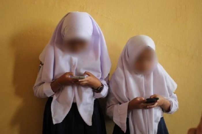 Ilustrasi: pelajar perempuan di Indonesia tengah bermain gadget | dok/photo: UNICEF 2019