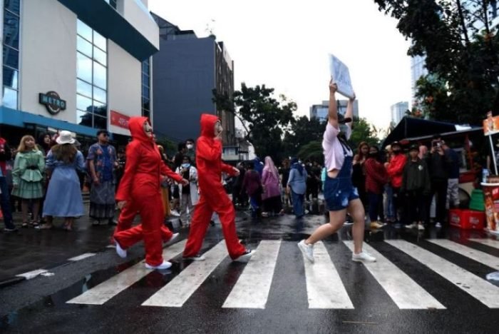 Warga berpose menampilkan busananya di atas zebra cross di kawasan Dukuh Atas, Jakarta, Sabtu (23/7/2022) | Source: Antara/Hafidz Mubarak A
