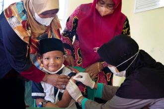 Anugrah Ramadhan mendapat imunisasi di klinik yang terletak di desa tempat tinggalnya di Tanjung Pinang | dok/photo: UNICEF/Clark