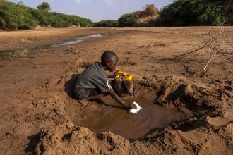 Seorang anak laki-laki di Dollow, Somalia mengumpulkan sedikit air yang dia dapat dari sungai kering | dok/photo: © UNICEF/UN0607653/Rich