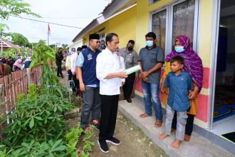 Presiden Jokowi saat menyerahkan sertifikat hak atas tanah kepada para penerima huntap | dok/photo: BPMI Setpres