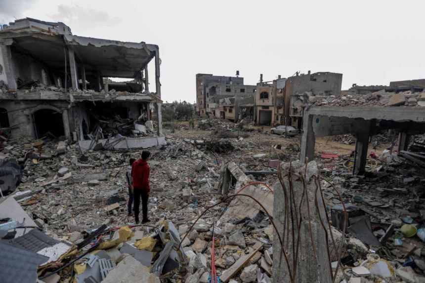Warga Palestina memeriksa dampak kehancuran akibat serangan udara terhadap rumah mereka di kawasan Khuza'a di Khan Yunis, Gaza pada 27 November 2023 | Source: Getty Images / Ahmad Hasaballah