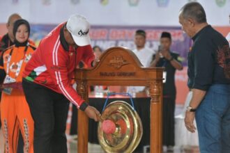 Penjabat (Pj) Gubernur Aceh Safrizal ZA, memukul gong tanda dimulainya Kejuaraan PON XXI Aceh-Sumut 2024 Cabang Olahraga Tarung Darajat, di Bale Meuseuraya Aceh, Senin (16/9/2024) Foto: MC ACEH