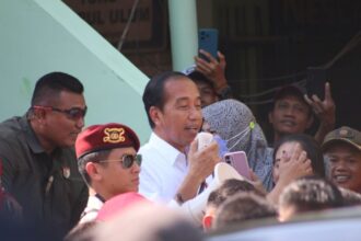 Presiden Jokowi menyapa masyarakat menggunakan megafon saat kunjungan di Pasar Soponyono, Surabaya, Jawa Timur, Jumat (6/9/2024) | Foto: An/BI