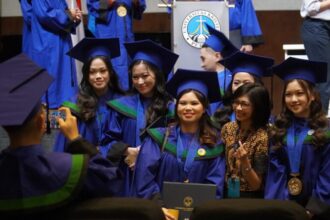 Senyum bahagia para wisudawan PCU yang sedang asyik berfoto bersama salah satu dosen