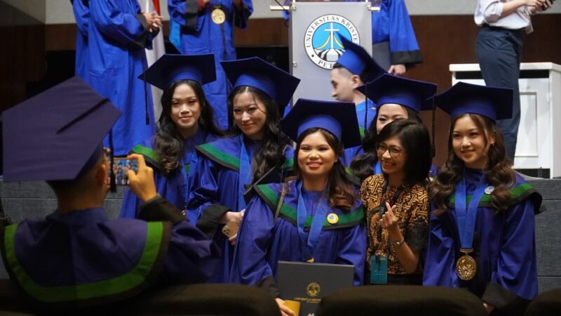 Senyum bahagia para wisudawan PCU yang sedang asyik berfoto bersama salah satu dosen