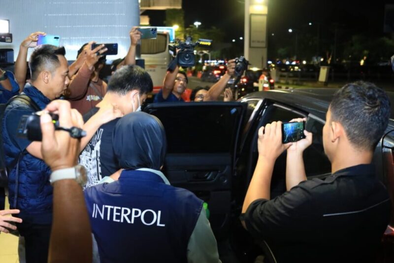 Petugas membawa tersangka DPO kasus judi online yang beroperasi dari luar negeri setibanya di Terminal 3 Bandara Soekarno Hatta, Tangerang, Banten, Jumat (22/11/2024) | Sumber Foto: Polri