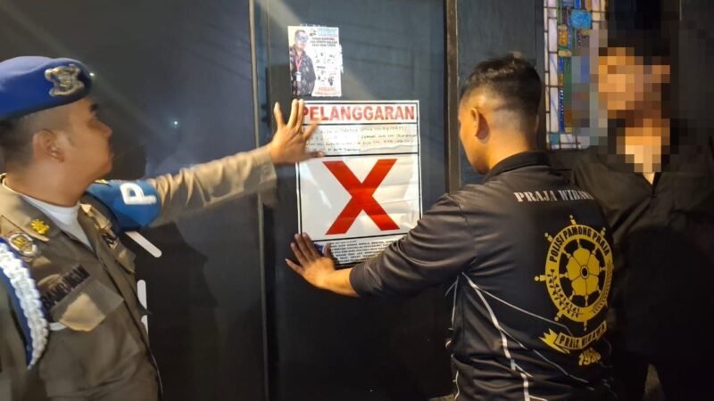 Petugas Satpol PP memasang stiker tanda pelanggaran pada Rekreasi Hiburan Umum (RHU) sebagai bentuk peringatan, Jumat (21/3/2025) dini hari. | Sumber Foto: Pemkot Surabaya