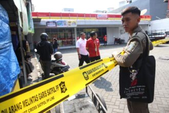 Petugas memasang garis Satpol PP Line terhadap salah satu toko modern di Surabaya, Selasa (10/6/2025) | Sumber Foto: Pemkot Surabaya