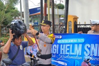 Kapolres Trenggalek, AKBP Ridwan Maliki, membagikan helm gratis kepada salah satu pengendara motor | Sumber Foto: Hum-Res
