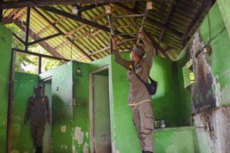 dok. Petugas Satpol PP Surabaya membersihkan toilet umum yang dialihfungsikan menjadi rumah tinggal | Sumber Foto: Pemkot Surabaya.
