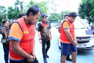 Ayah dan anak terduga pelaku pencurian lampu hias saat digelandang di Mapolrestabes Surabaya, Jumat (14/11/2025) | Foto: Ariandi K/BI