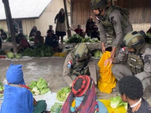 Personel Satgas Operasi Damai Cartenz saat membeli hasil bumi di Pasar Distrik Sinak, Kabupaten Puncak, Papua Tengah, Minggu (22/3/2026) (Sumber Foto: Hum/Polri)