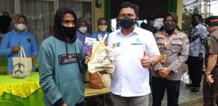 Direktur Hubungan Kelembagaan PT Jasa Raharja, Munadi Herlambang (kanan depan) saat menyerahkan paket sembako kepada warga | dok/photo: Ist /Bicara Indonesia